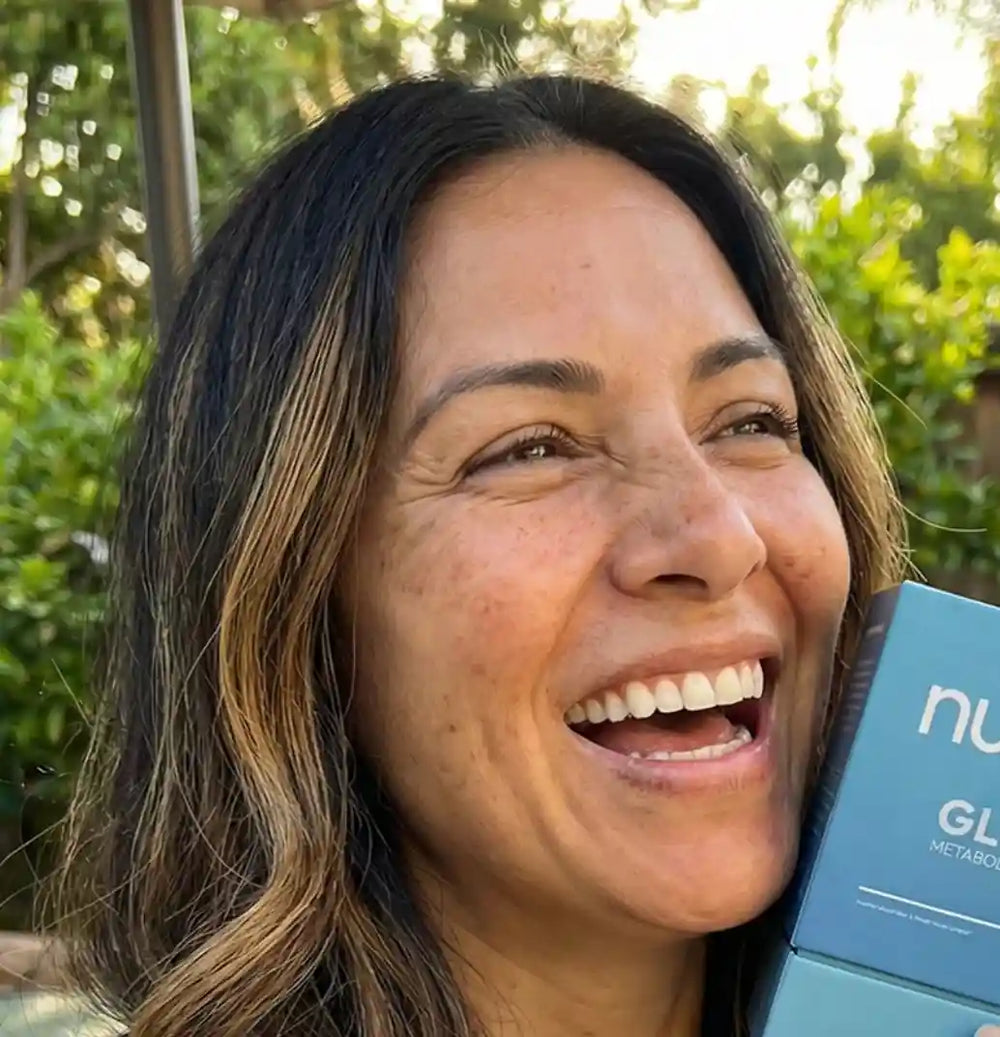 Happy customer laughing outdoors with Nume GLP-1 box