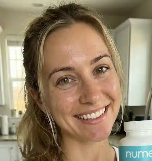 Customer smiling with Nume GLP-1 bottle in kitchen